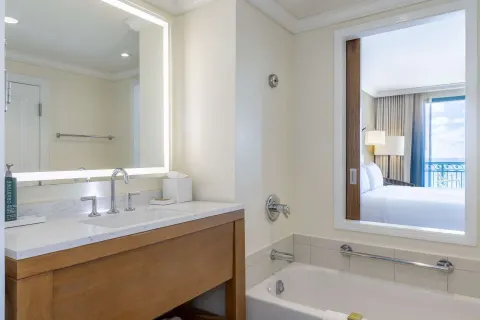 Premium Room bathroom with tub, vanity, and ocean-view bedroom beyond at Hilton Barbados Resort.