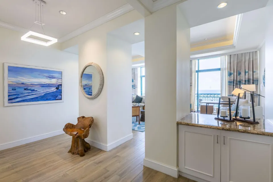 Premium suite entry hall with ocean artwork and living area at Hilton Barbados Resort.