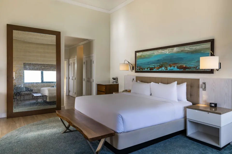 Premium suite bedroom with king bed and mirror at Hilton Barbados Resort.