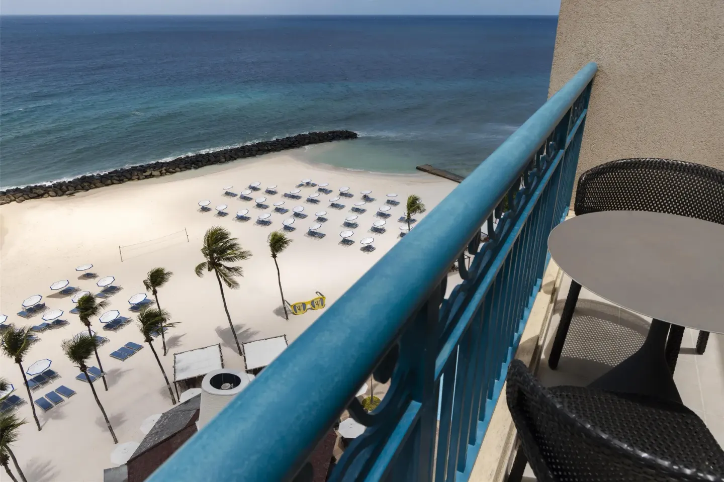 Premium Suite balcony overlooking beach loungers and ocean at Hilton Barbados Resort.