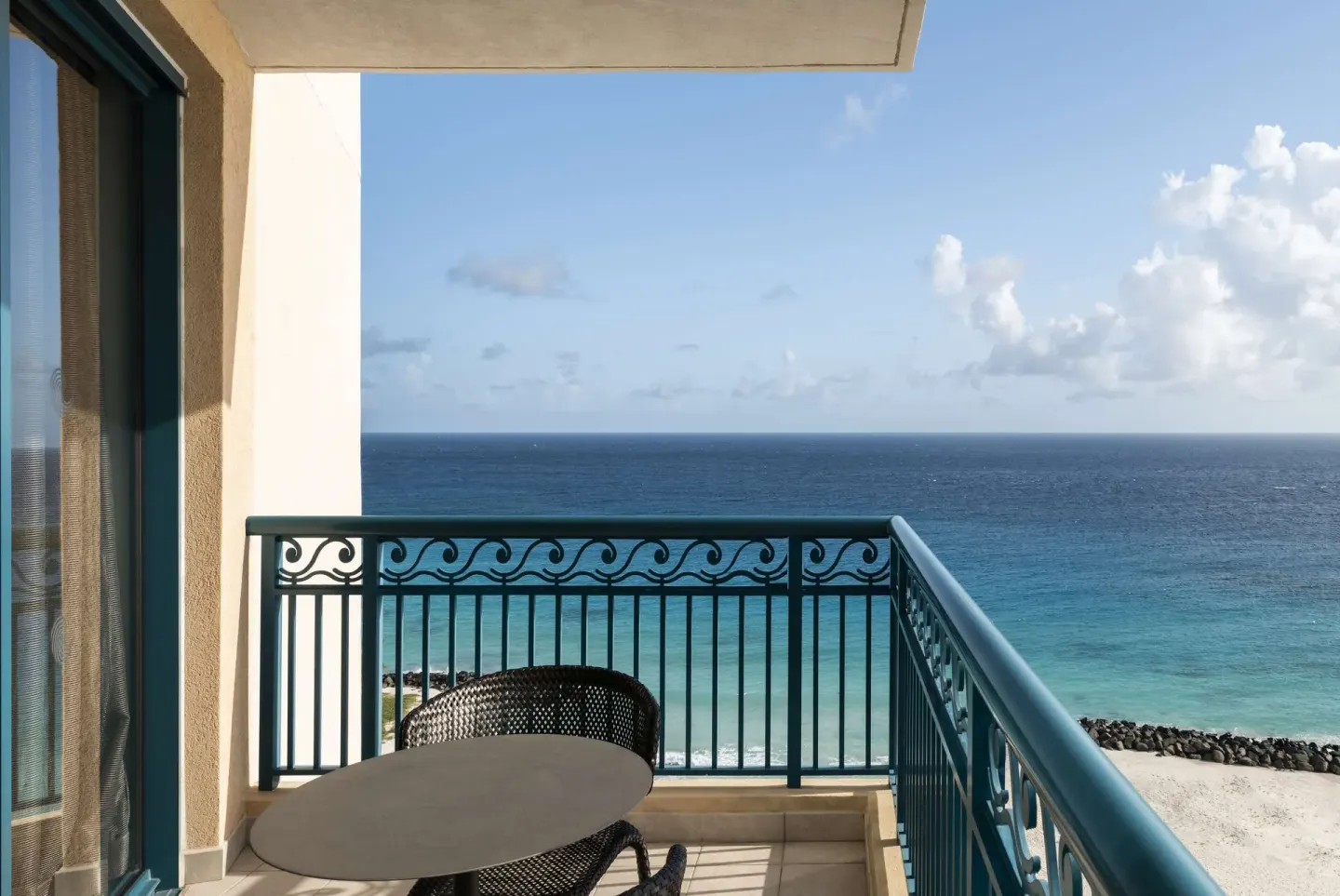 Premium Suite balcony with table and ocean view at Hilton Barbados Resort.