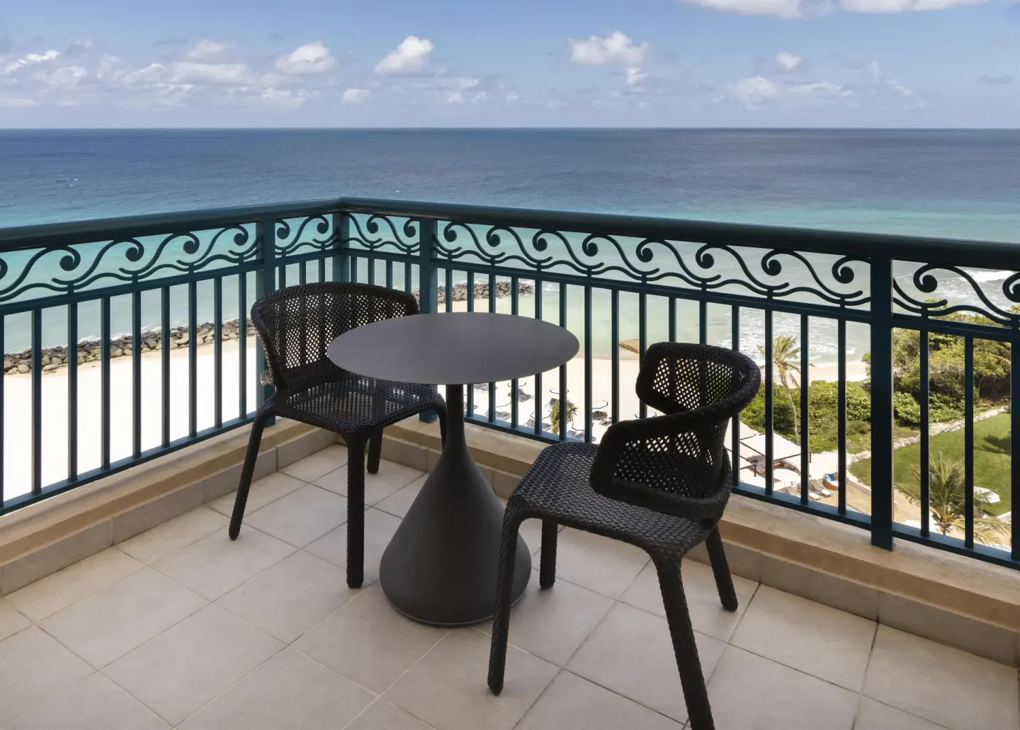 Premium Suite corner balcony with two chairs and ocean beyond at Hilton Barbados Resort.