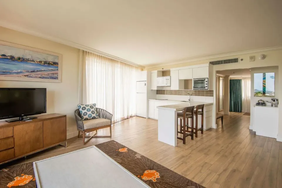Residence 1 Bedroom Suite kitchenette with TV and lounge seating at Hilton Barbados Resort.