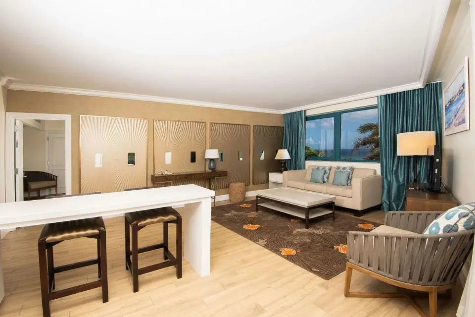 Residence 1 Bedroom Suite sitting area with sofa and counter seating at Hilton Barbados Resort.