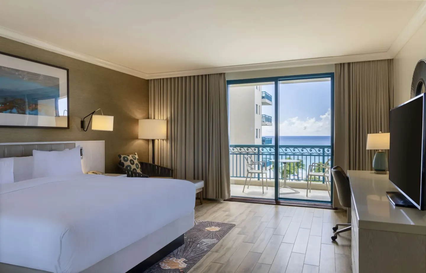 King bed accessible ocean view room with balcony seating at Hilton Barbados Resort.