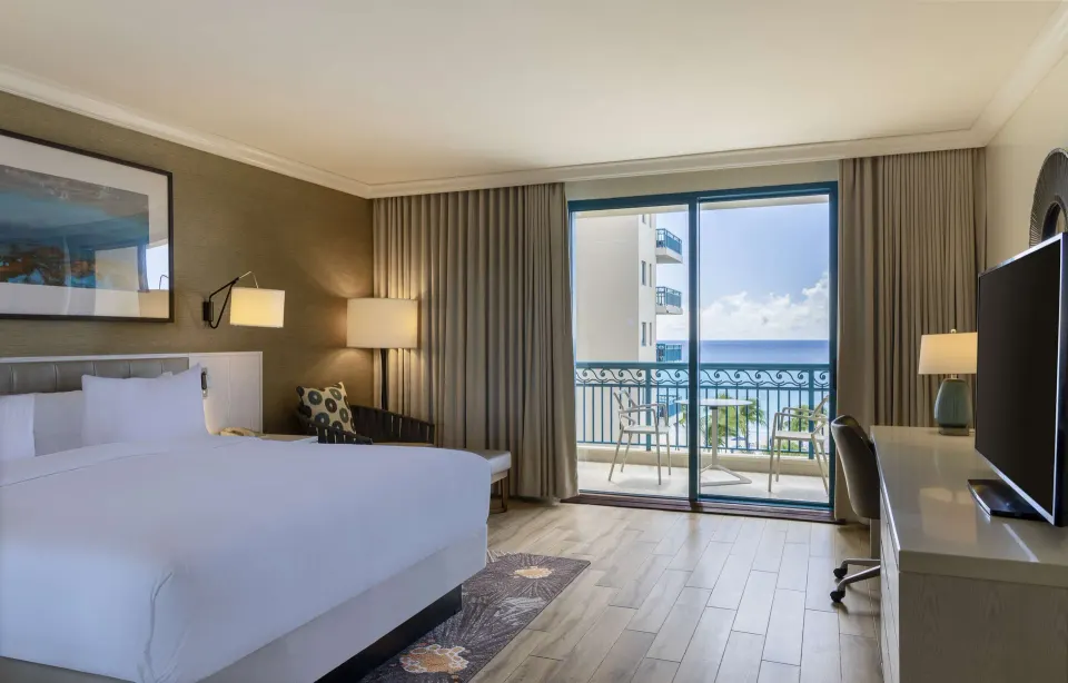 King bed accessible ocean view room with balcony seating at Hilton Barbados Resort.