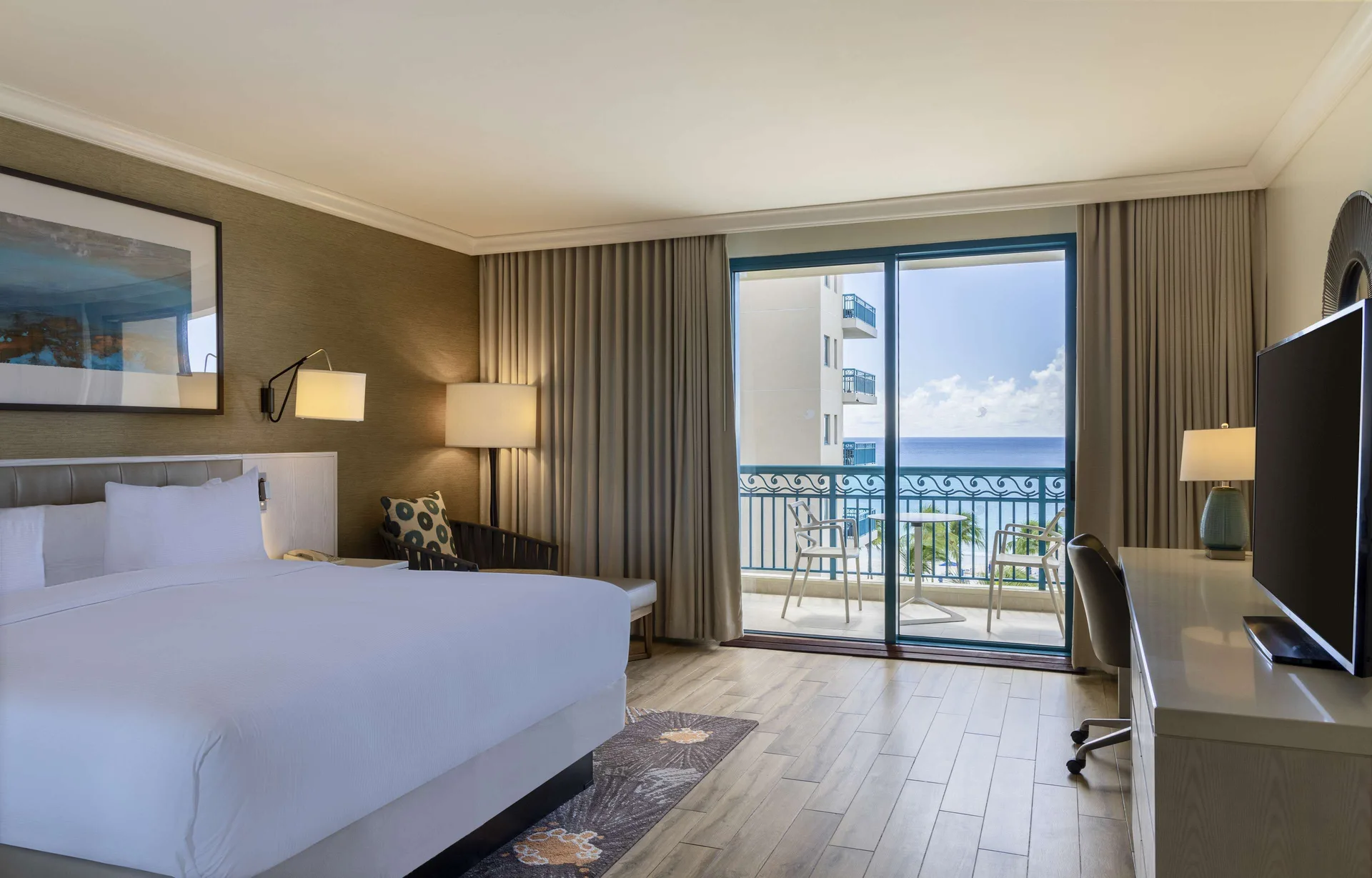 King bed accessible ocean view room with balcony seating at Hilton Barbados Resort.