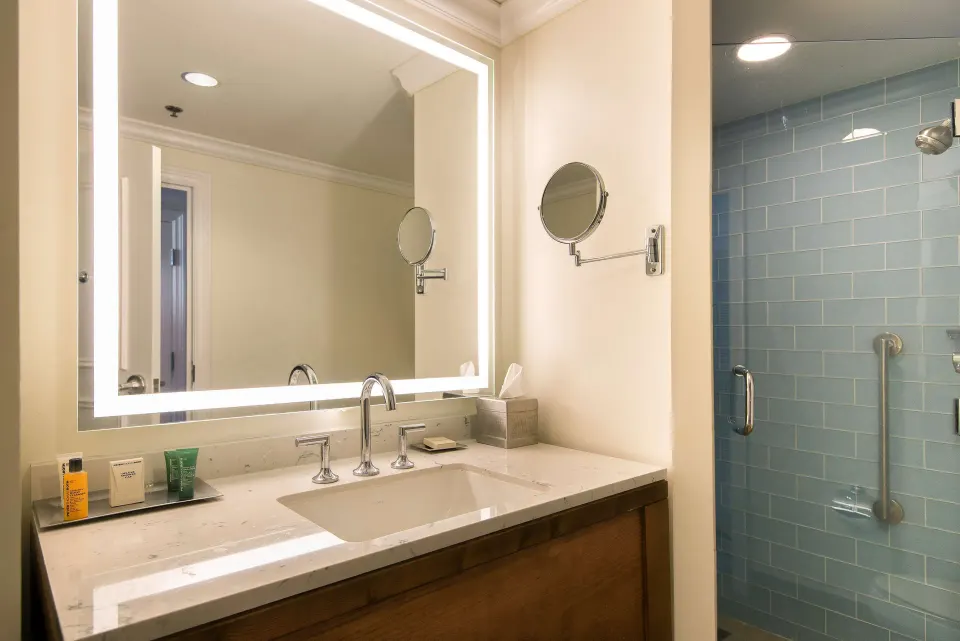 Room Bay View bathroom at Hilton Barbados Resort with vanity and blue-tile shower.