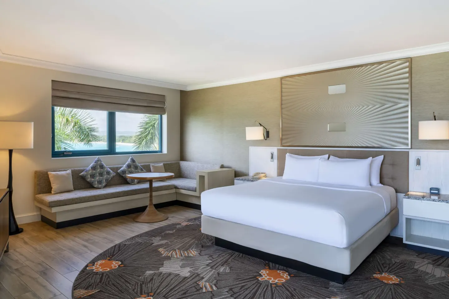 Corner room king bed with lounge seating and window view at Hilton Barbados Resort.