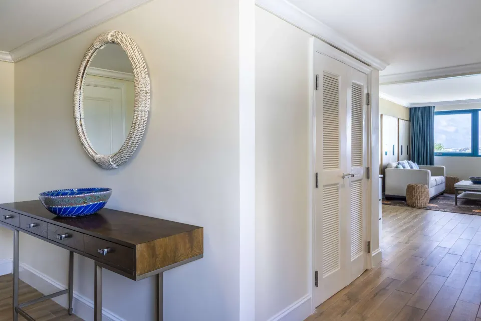 One Bedroom Suite entry with console, mirror and living area beyond at Hilton Barbados Resort.