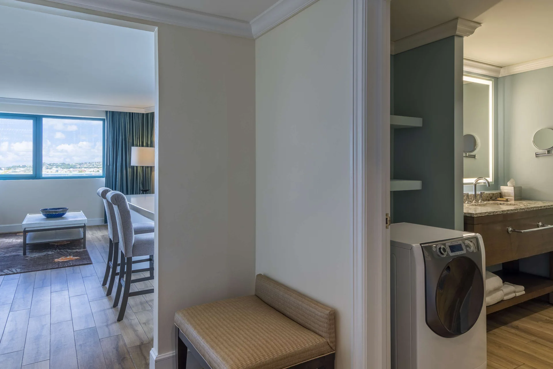 One Bedroom Suite hallway with laundry area and living room view at Hilton Barbados Resort.