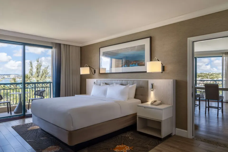 One Bedroom Suite king bed with balcony access at Hilton Barbados Resort.