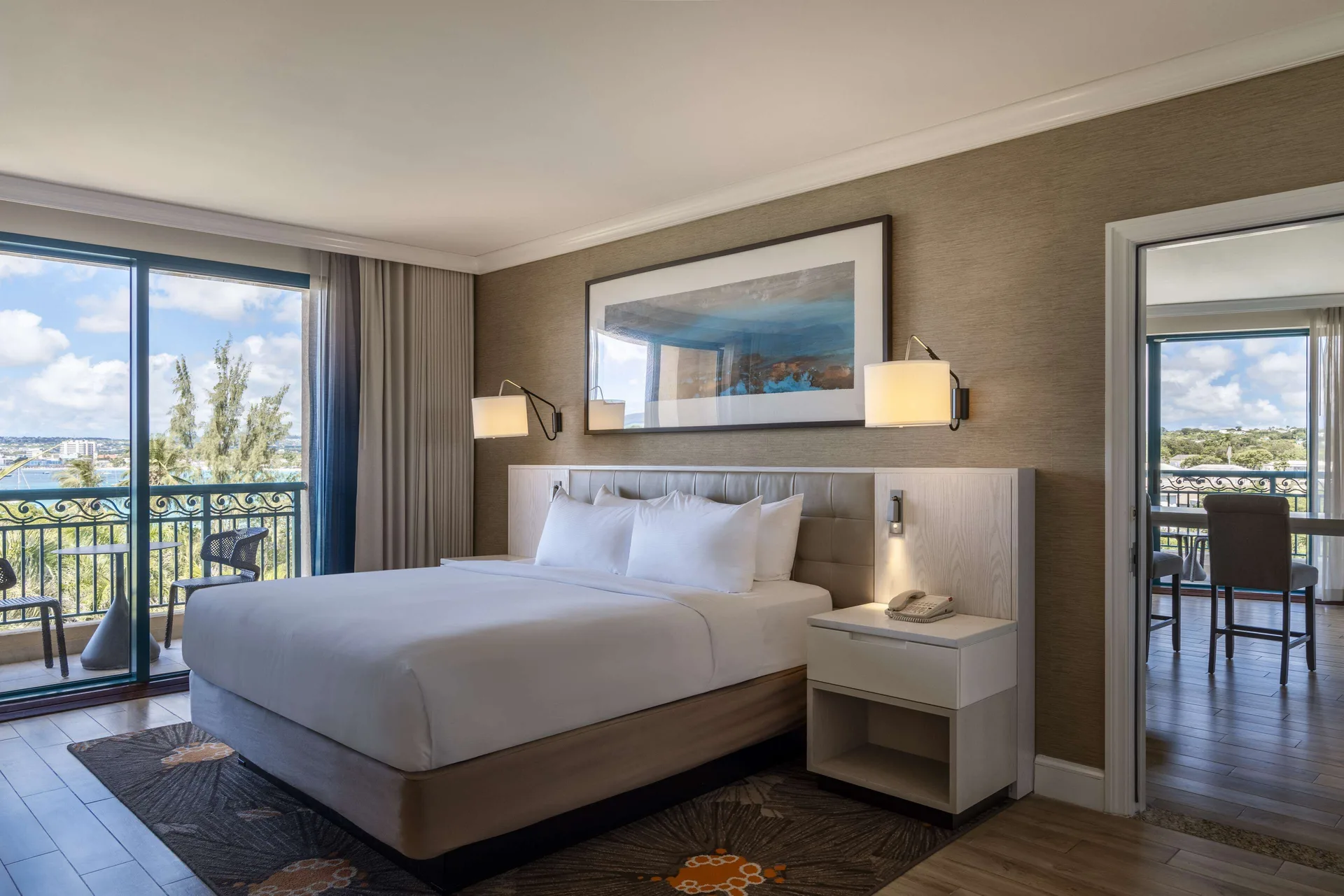 One Bedroom Suite king bed with balcony access at Hilton Barbados Resort.