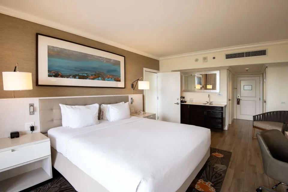 One Bedroom Suite king bed with vanity and seating at Hilton Barbados Resort.