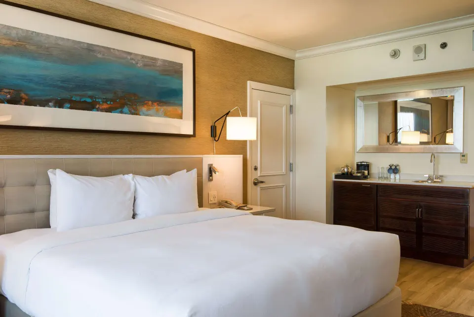 One Bedroom Suite king bed and wet bar area at Hilton Barbados Resort.