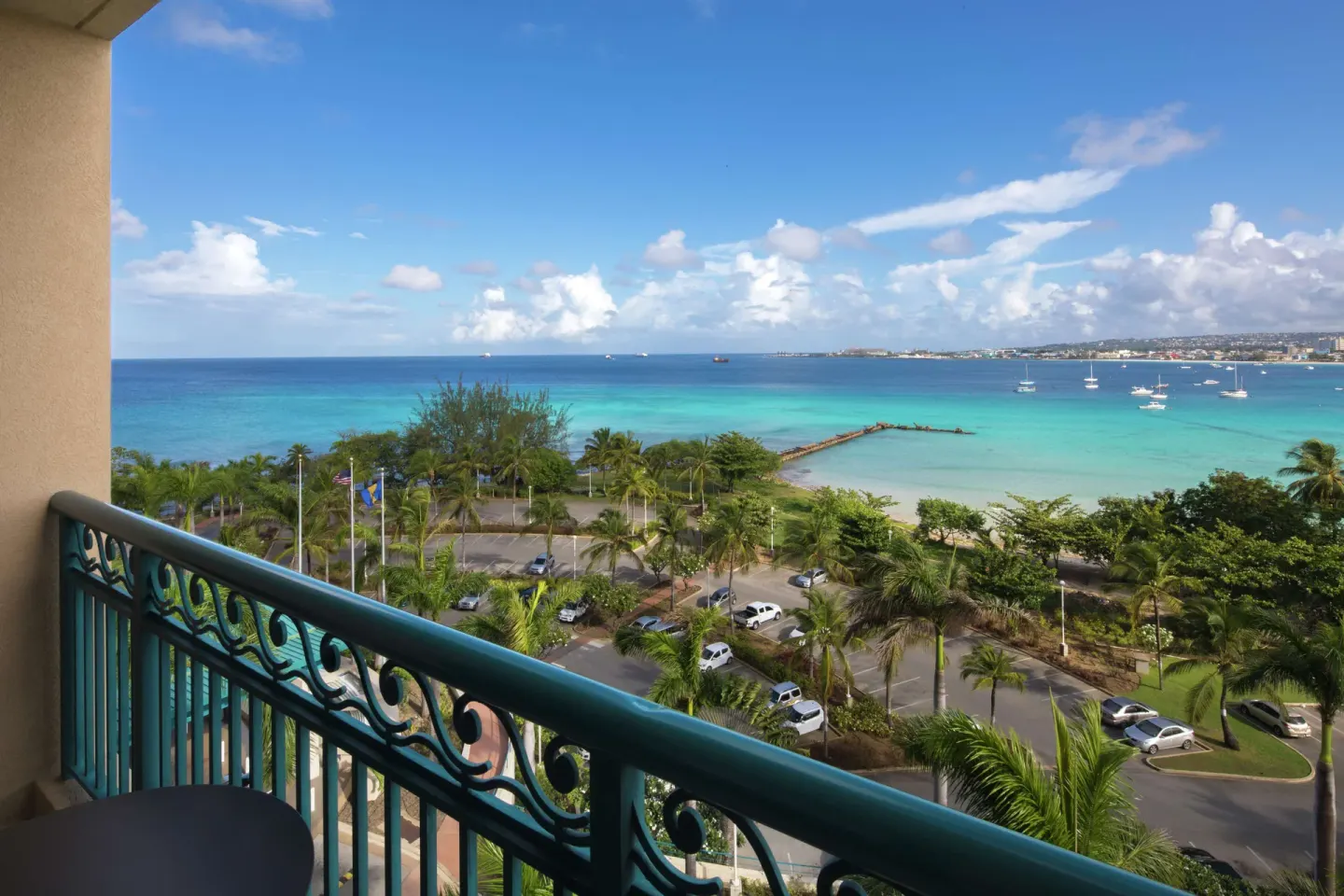 Corner suite balcony view of turquoise bay and palm-lined grounds at Hilton Barbados Resort.