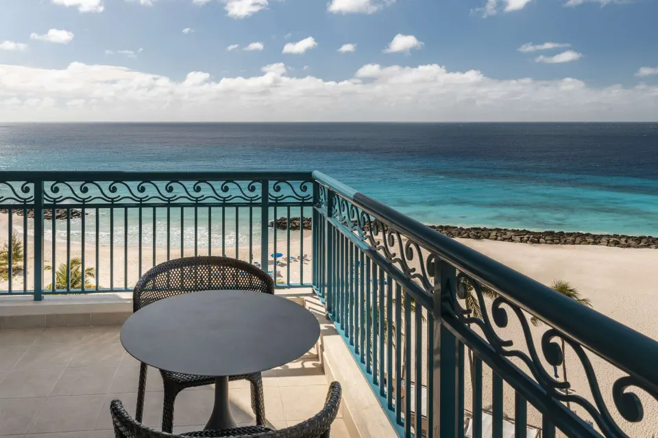 Corner suite balcony table overlooking the beach and ocean at Hilton Barbados Resort.