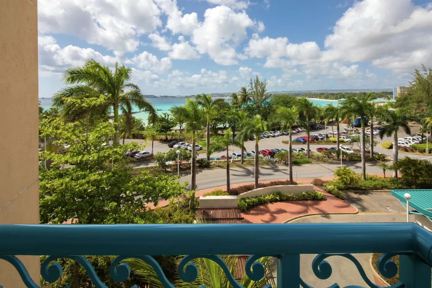 Corner suite balcony view over palms, road, and coastline at Hilton Barbados Resort.