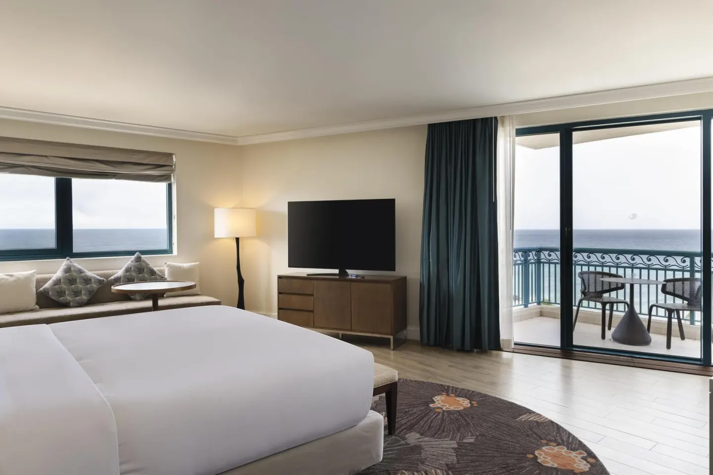 Corner ocean view suite bedroom with balcony at Hilton Barbados Resort.
