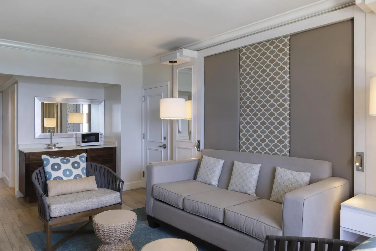 Corner ocean view suite living area with sofa and wet bar at Hilton Barbados Resort.