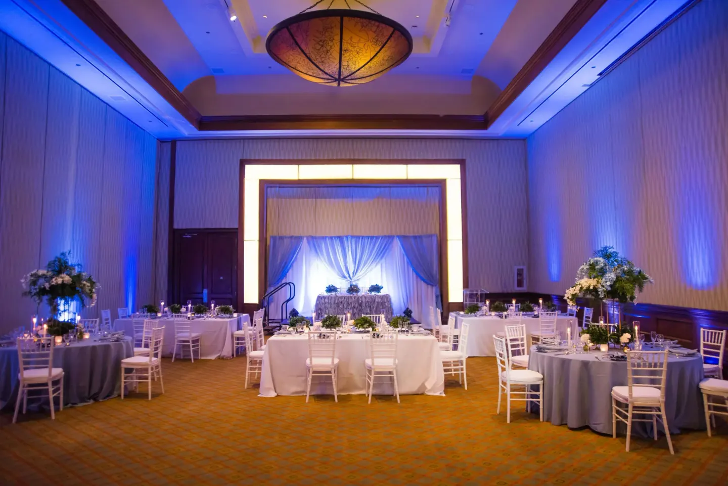 Blue-lit ballroom set for a wedding reception at Hilton Barbados Resort.