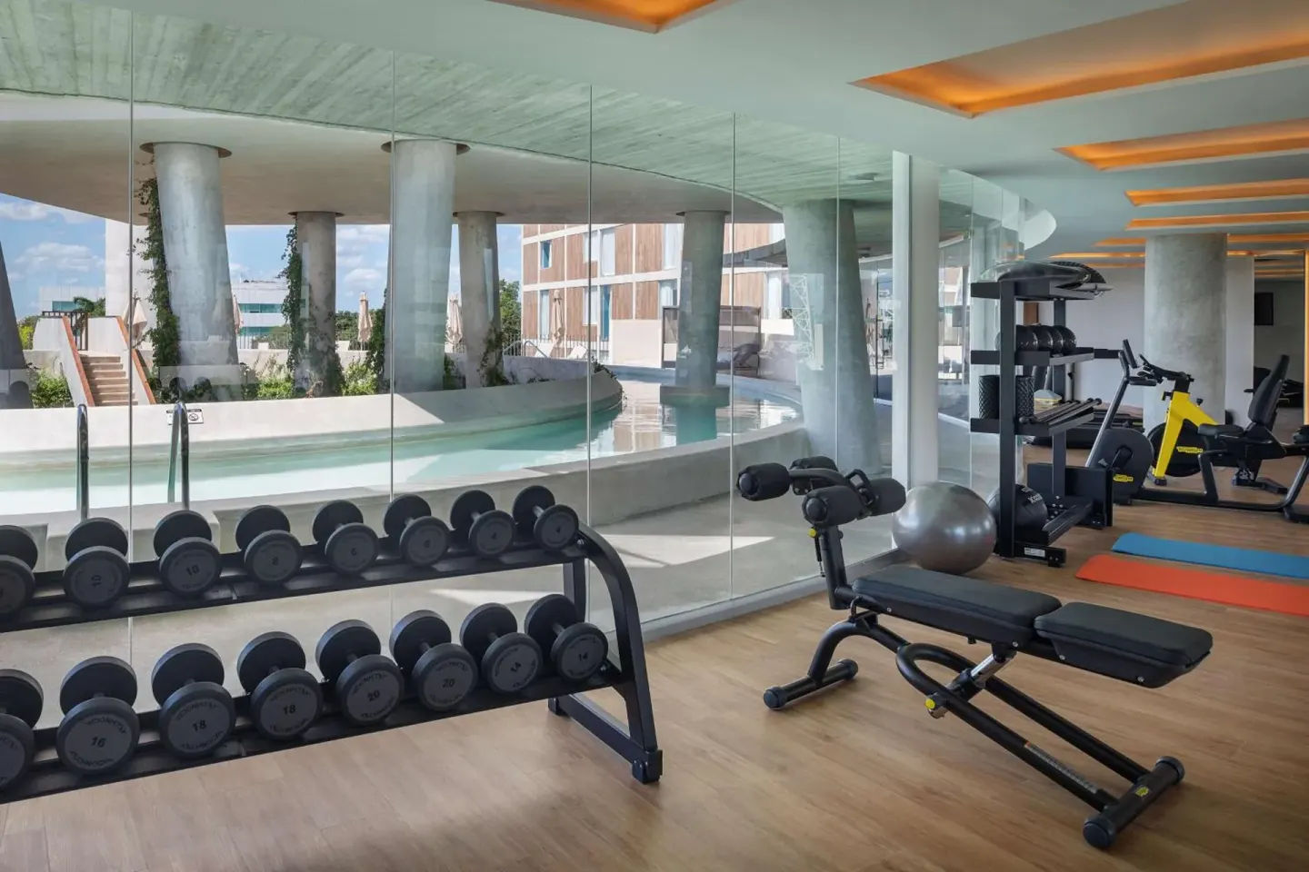 Fitness room with weights and pool view at Hilton Garden Inn Cancun Airport.