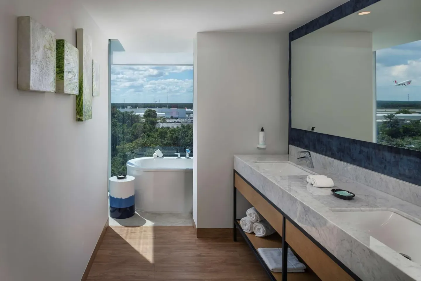 Guest bathroom with double vanity and tub by the window at Hilton Garden Inn Cancun Airport.