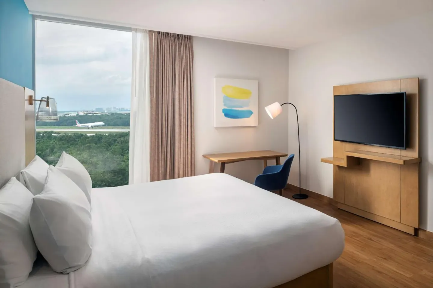 King bed guest room with airport view at Hilton Garden Inn Cancun Airport.