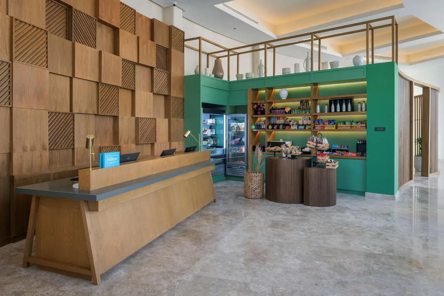 Lobby front desk and market shelves at Hilton Garden Inn Cancun Airport.