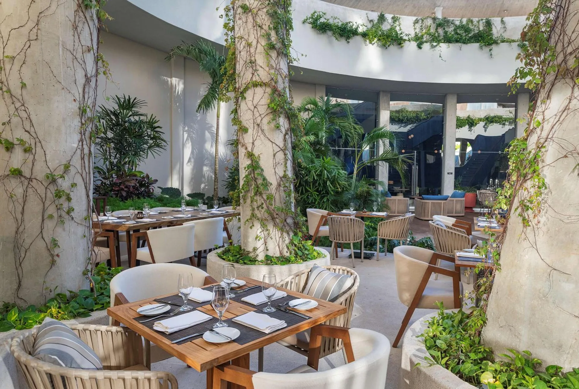 Garden courtyard dining tables at Hilton Garden Inn Cancun Airport.