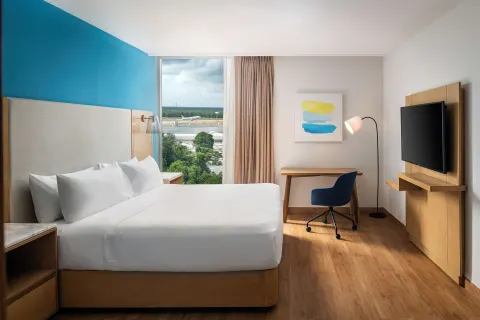 King guest room with airport-facing window at Hilton Garden Inn Cancun Airport.