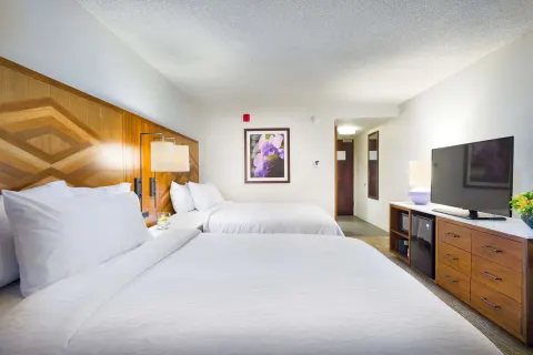 Ocean view room with two beds and TV at Hilton Garden Inn Kauai Wailua Bay.