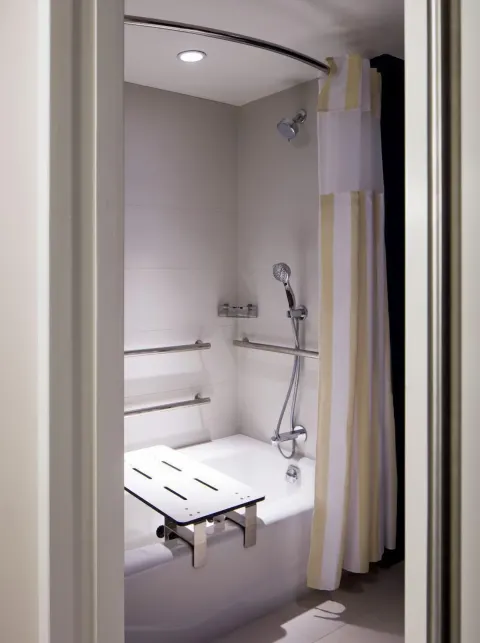 Accessible bathtub with grab bars and shower seat at Hilton Garden Inn Waikiki Beach.
