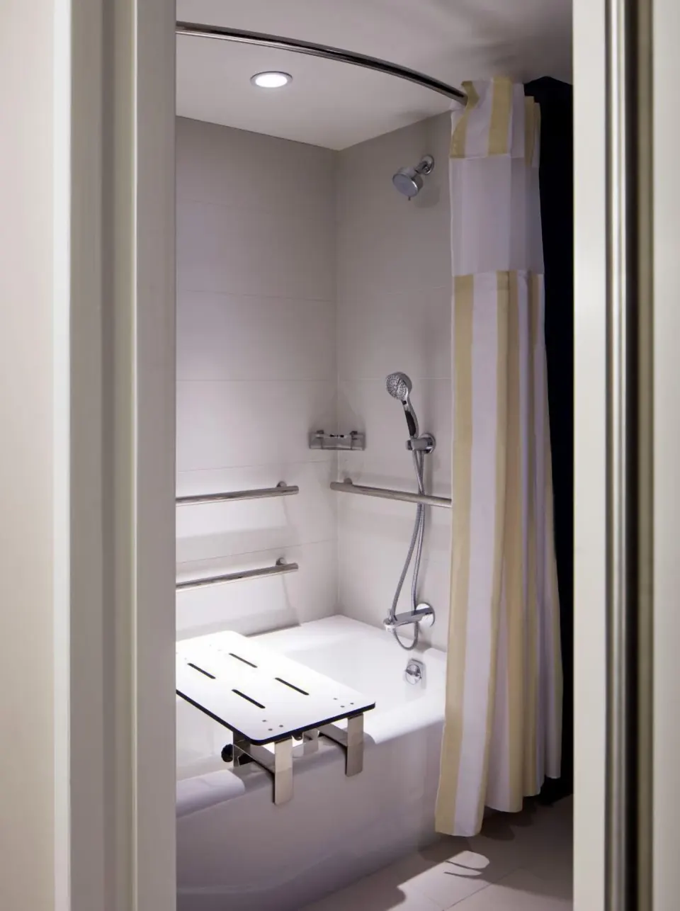 Accessible bathtub with grab bars and shower seat at Hilton Garden Inn Waikiki Beach.