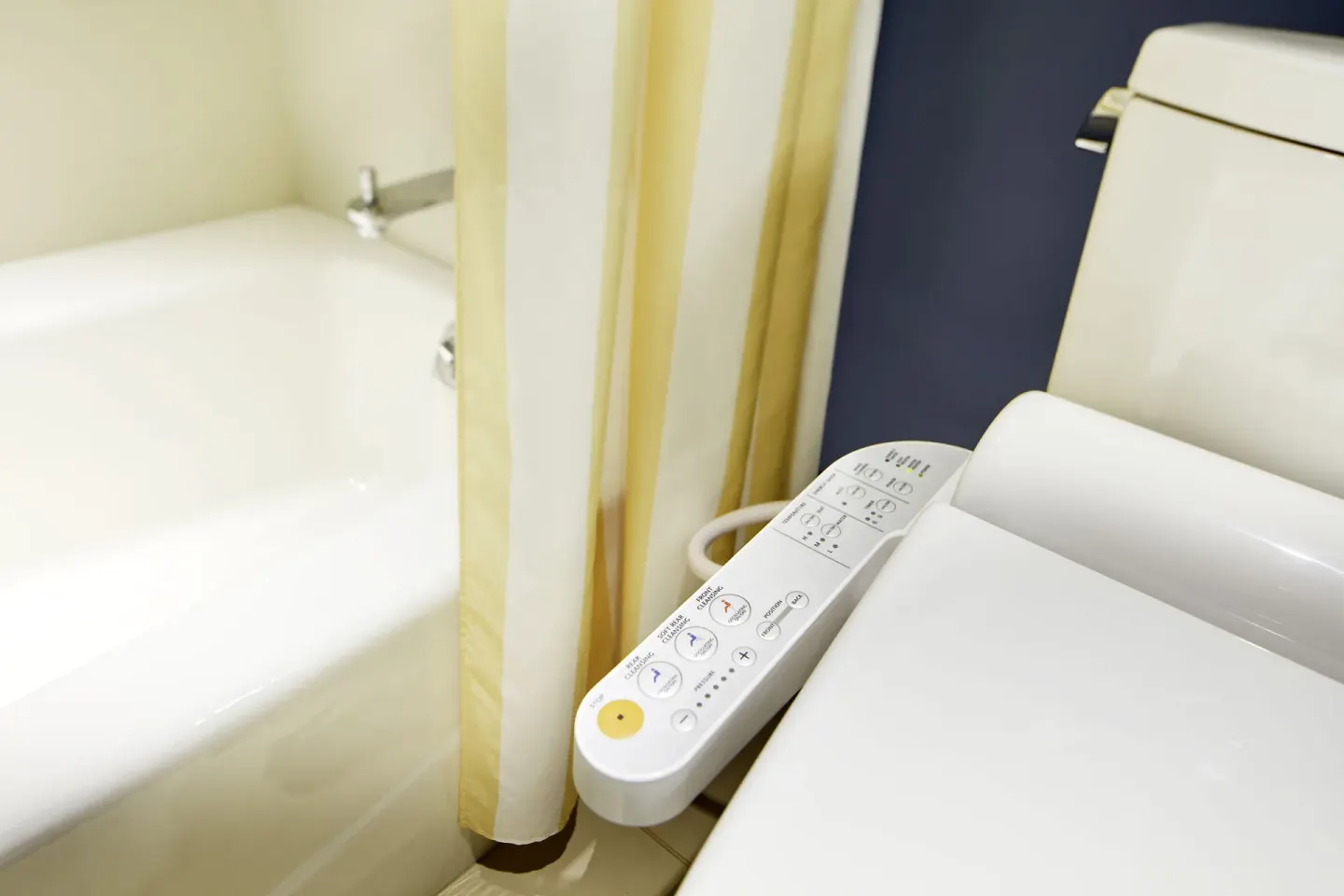 Bathroom toilet controls beside a bathtub at Hilton Garden Inn Waikiki Beach.