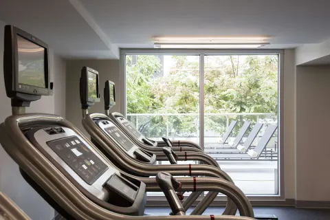 Treadmills facing large windows in the fitness center at Hilton Garden Inn Waikiki Beach.