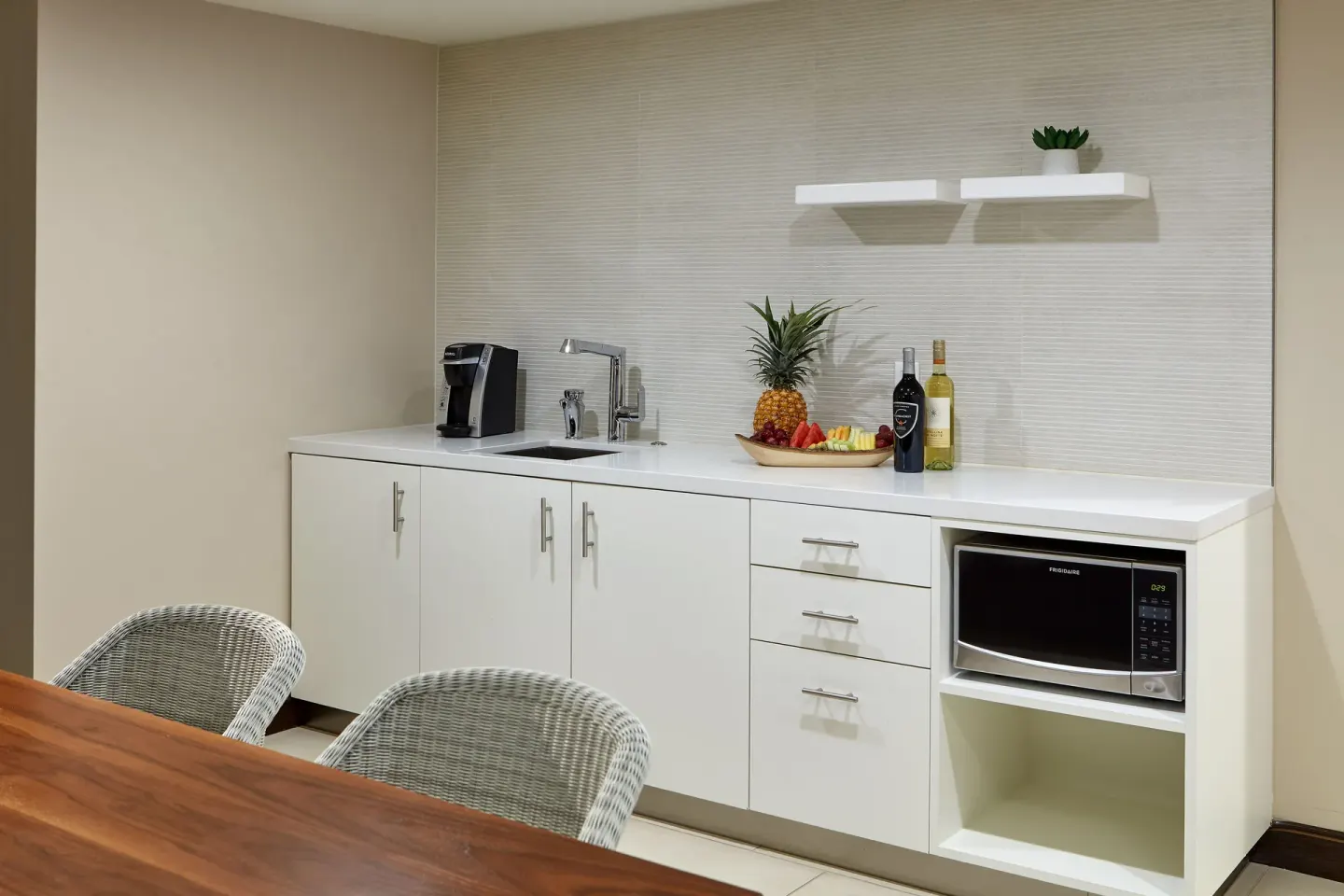 In-room wet bar with microwave and dining table at Hilton Garden Inn Waikiki Beach.