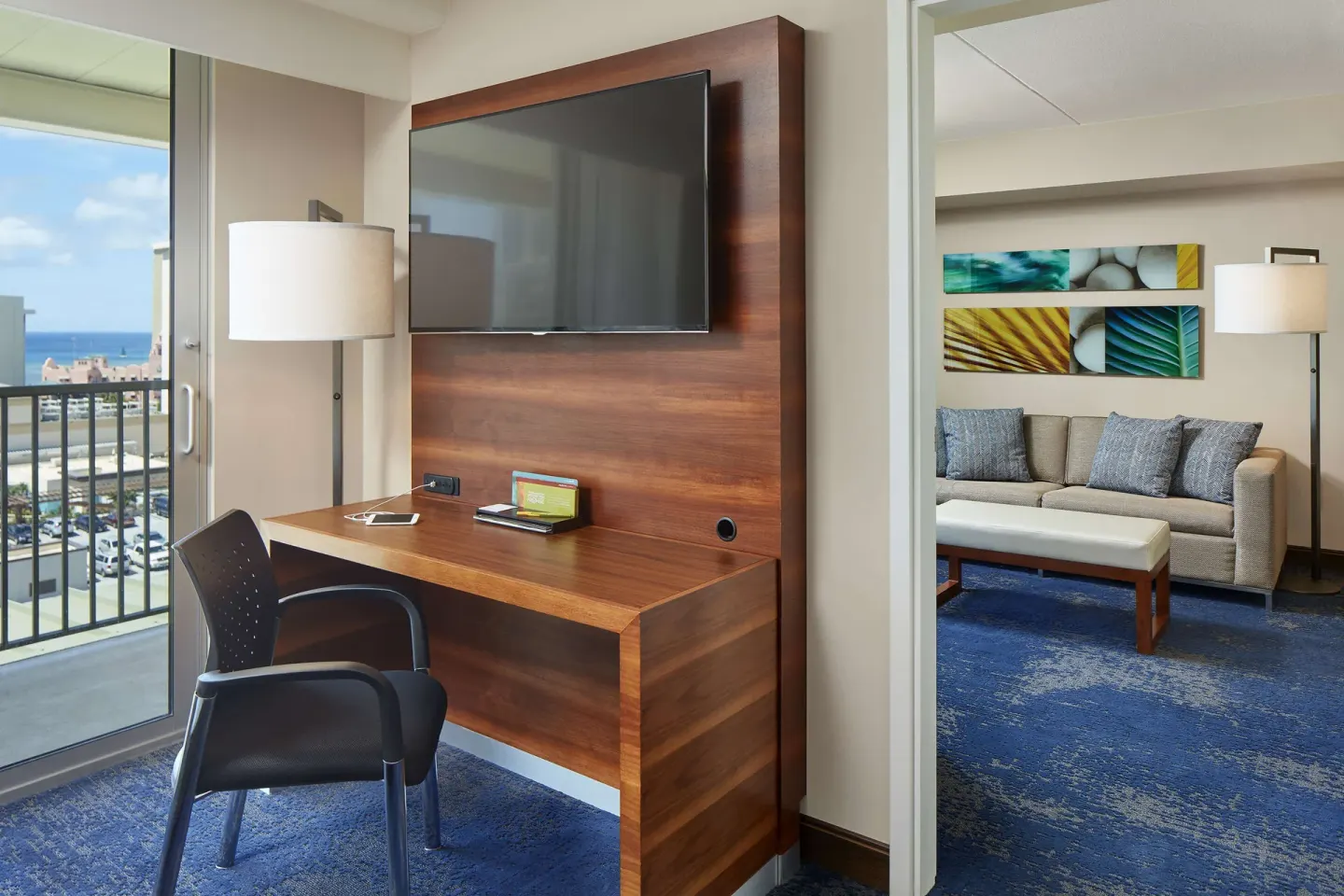 Suite work area with balcony and sitting room at Hilton Garden Inn Waikiki Beach.