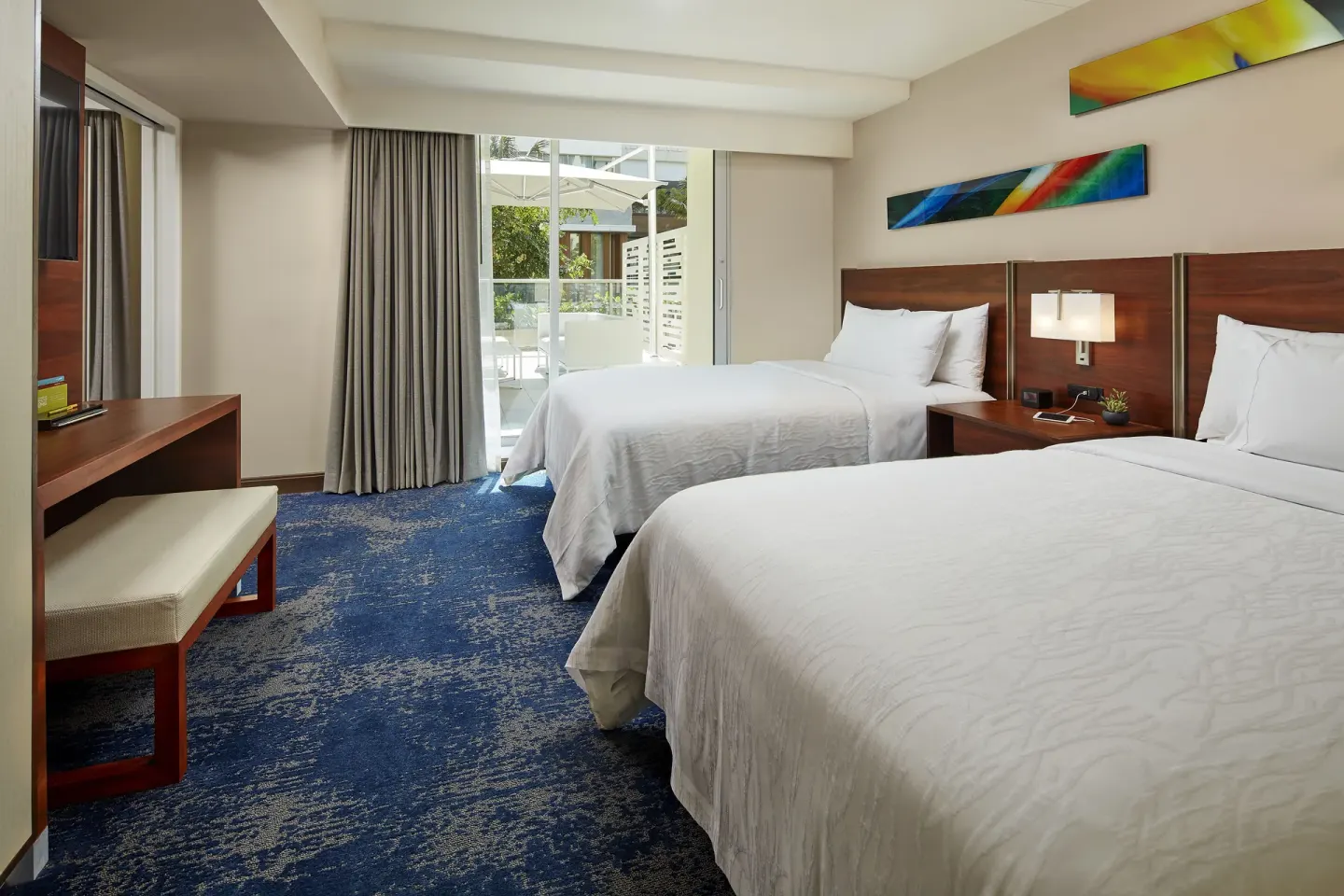 Accessible city view hearing room with two beds and patio doors at Hilton Garden Inn Waikiki Beach.