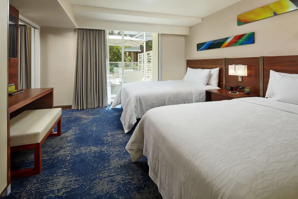 Accessible city view hearing room with two beds and patio doors at Hilton Garden Inn Waikiki Beach.