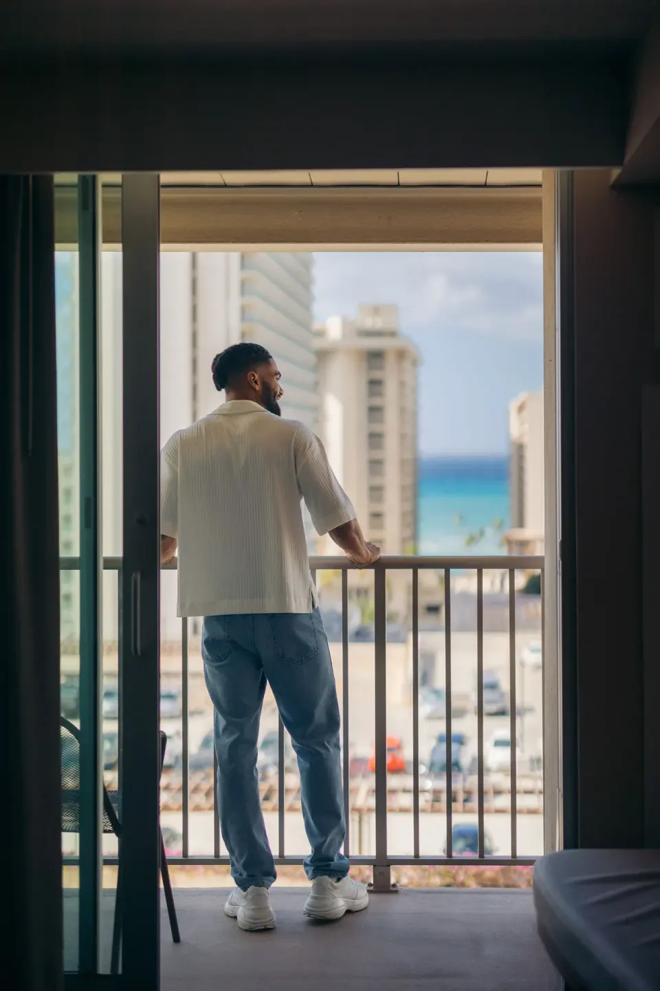Guest on the balcony of an accessible partial ocean view room at Hilton Garden Inn Waikiki Beach.