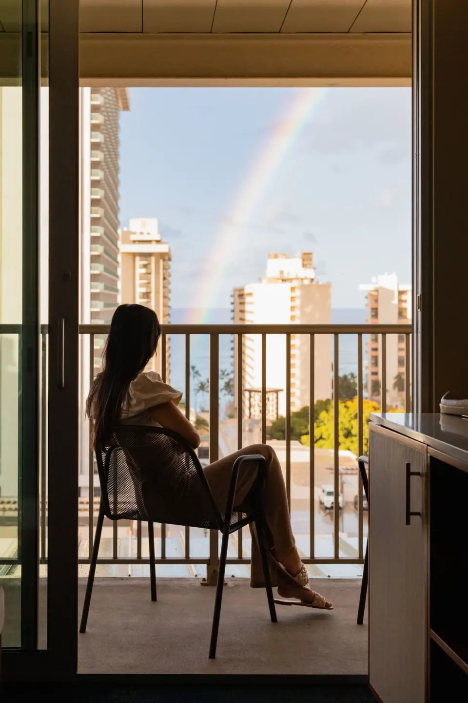 Balcony seating with a rainbow and partial ocean view at Hilton Garden Inn Waikiki Beach.