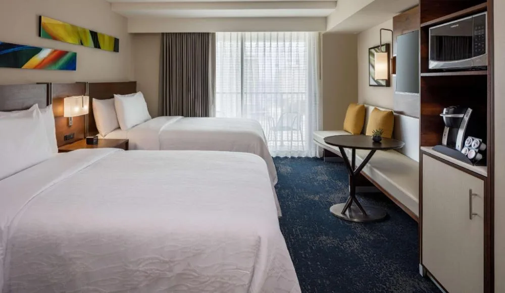 Two-bed standard room with seating nook at Hilton Garden Inn Waikiki Beach.