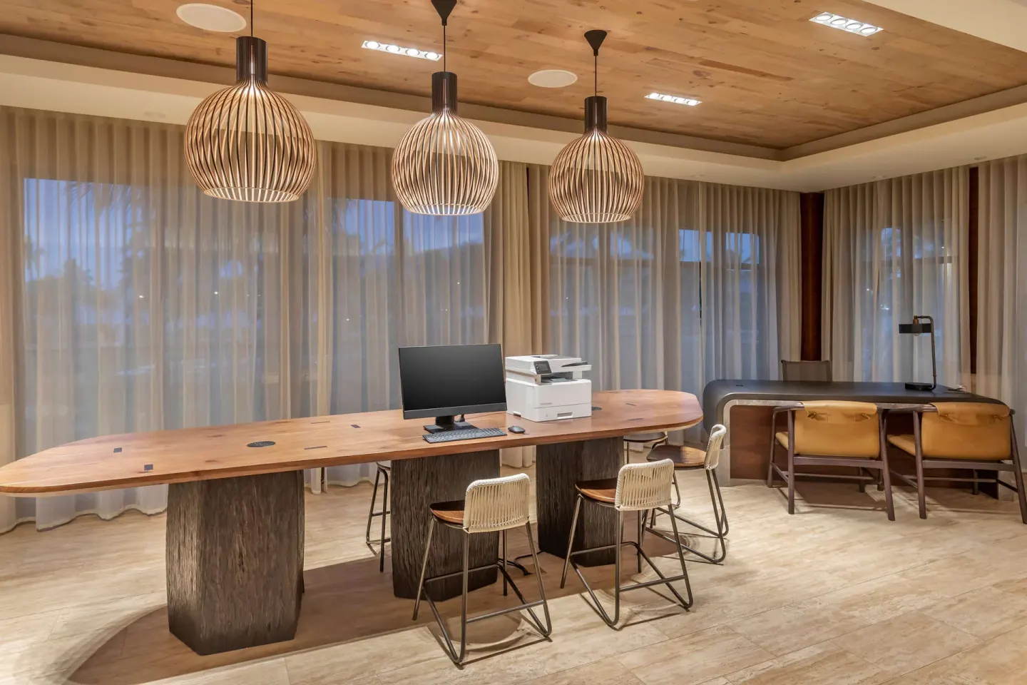 Business area with shared desks and pendant lights at Hilton Grand Vacations Club Maui Bay Villas.