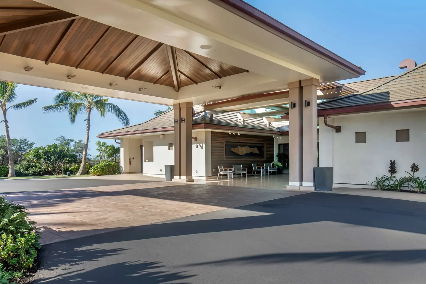 Covered arrival porte cochere at Hilton Grand Vacations Club Maui Bay Villas with palms and seating beyond.