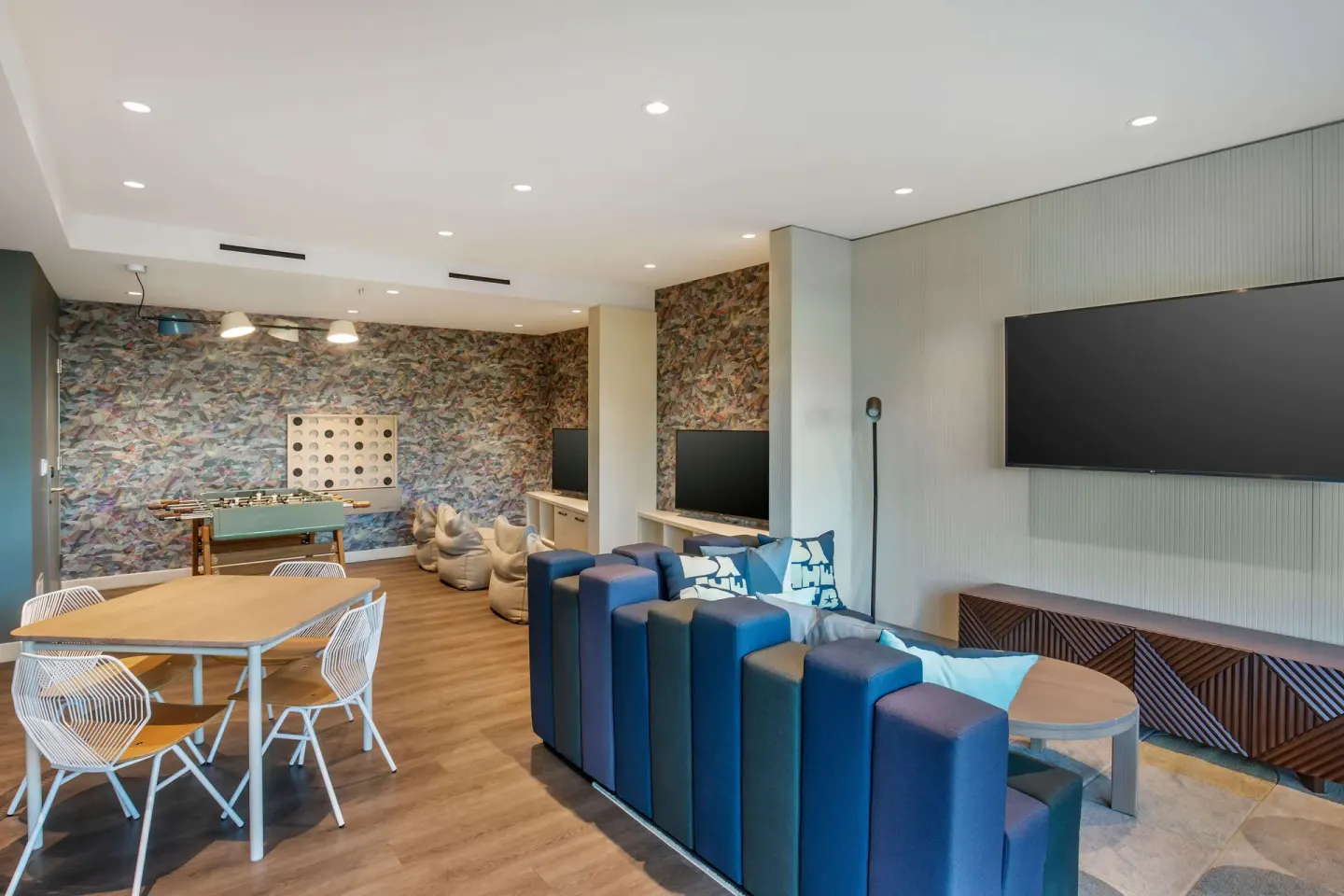 Game lounge with seating, TVs, and table games at Hilton Grand Vacations Club Maui Bay Villas.
