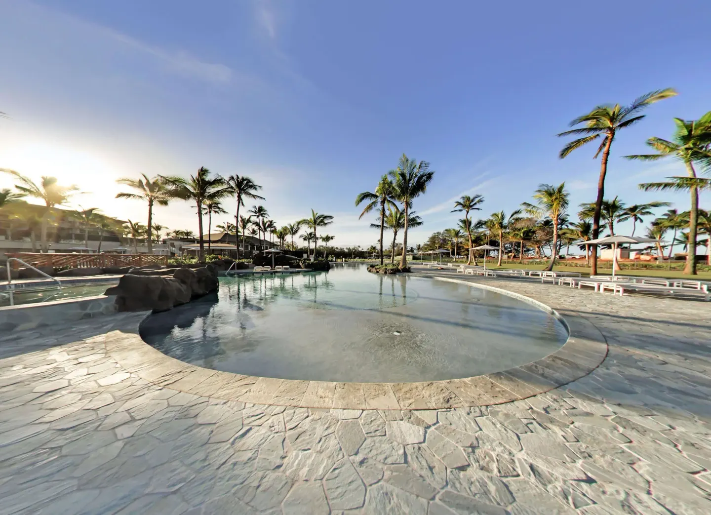 Wide lagoon pool deck with palms at Hilton Grand Vacations Club Maui Bay Villas.
