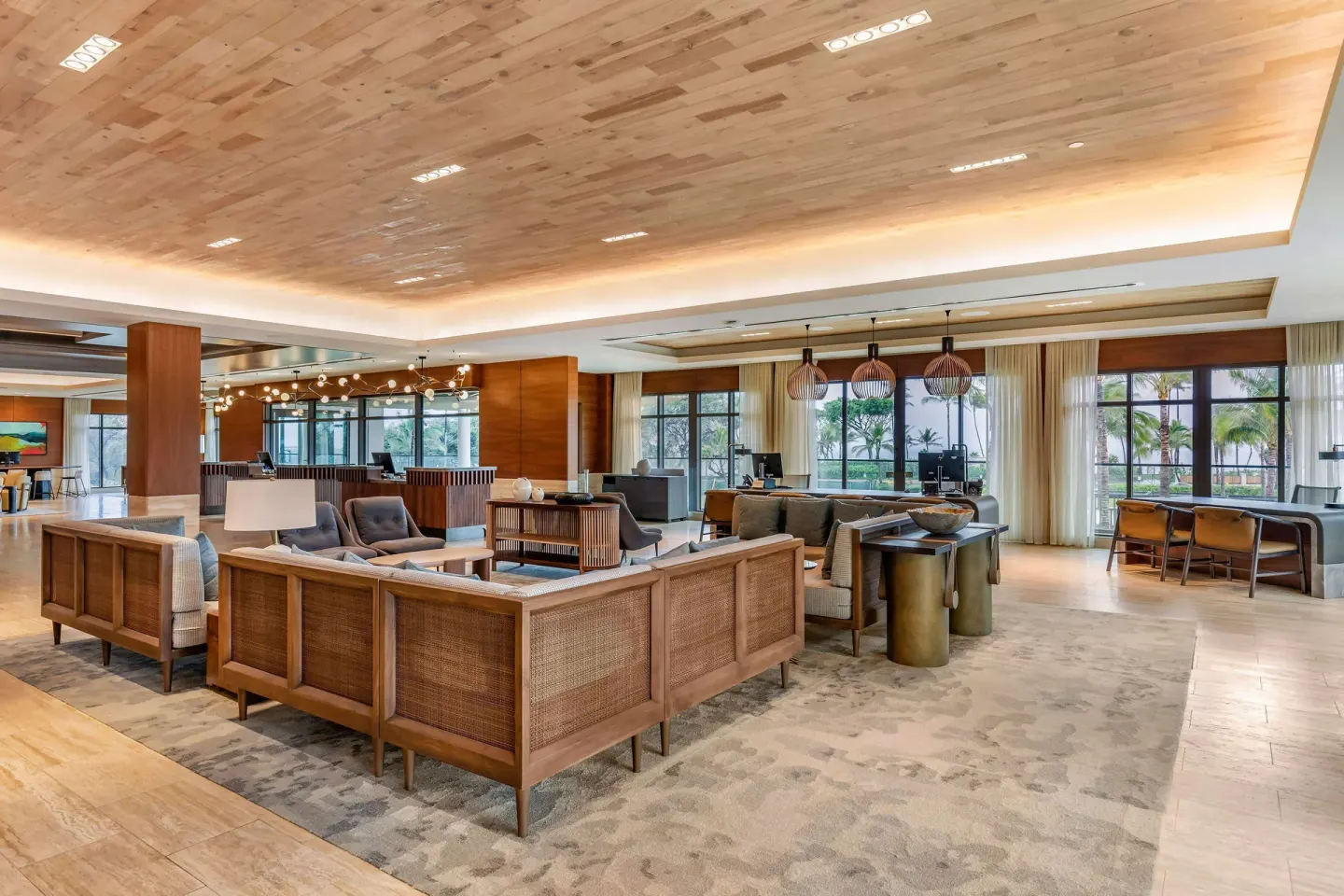 Lobby seating area with desks and large windows at Hilton Grand Vacations Club Maui Bay Villas.
