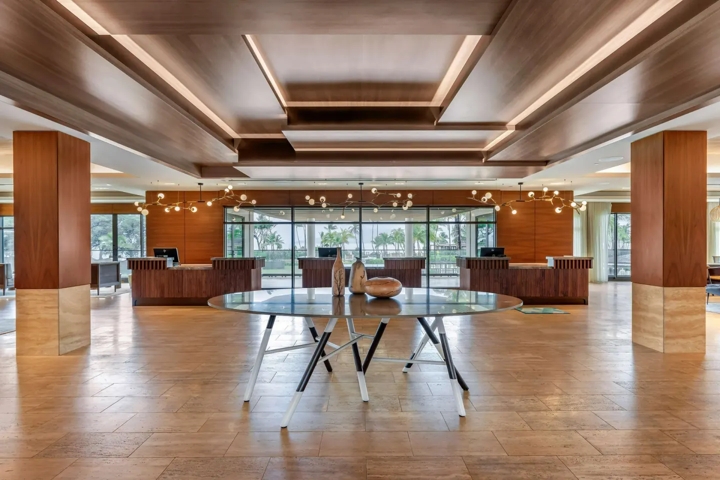 Symmetrical lobby view with a round table and reception desks at Hilton Grand Vacations Club Maui Bay Villas.