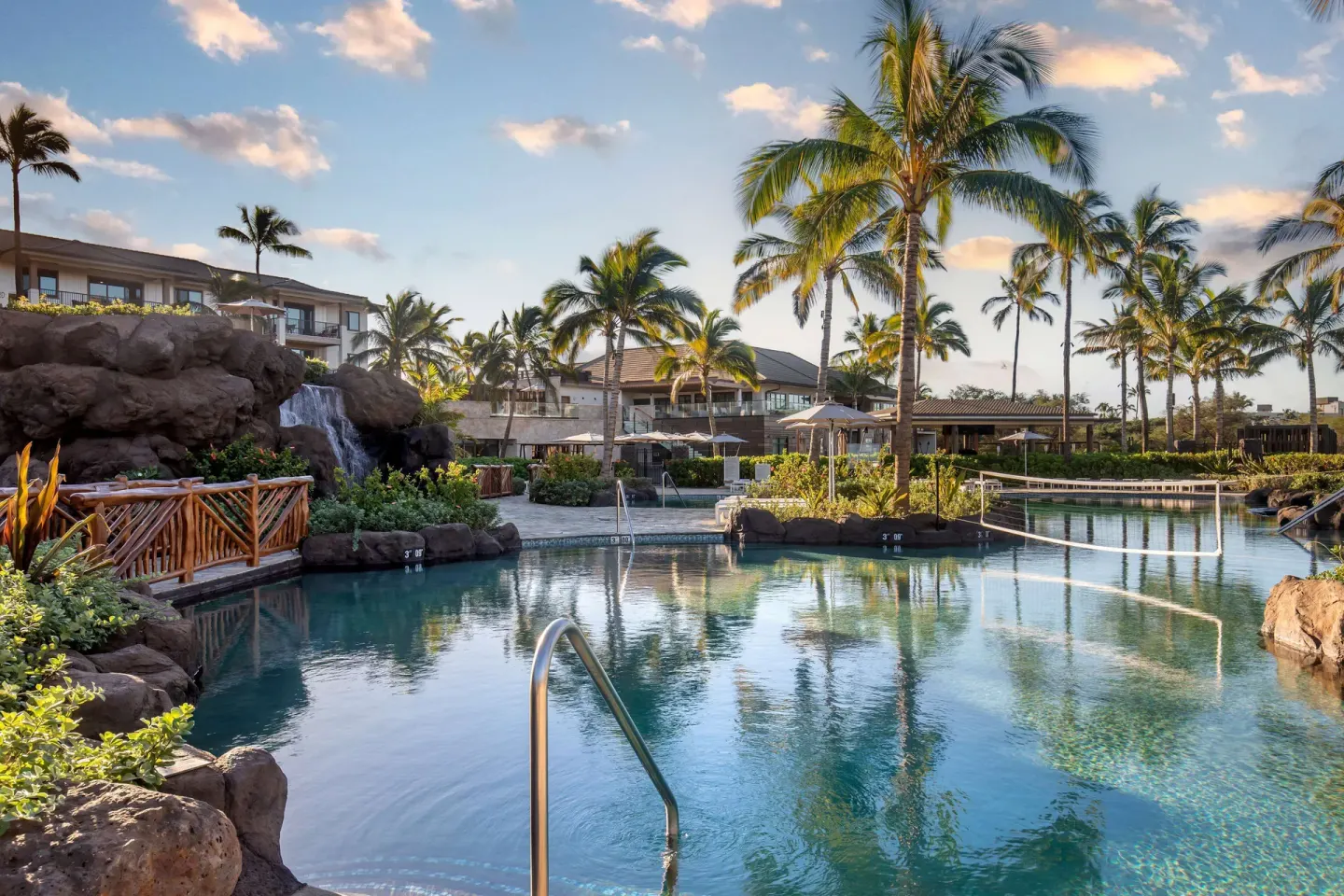 Pool with waterfall rock feature and palms at Hilton Grand Vacations Club Maui Bay Villas.